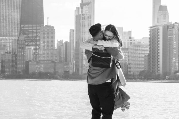 couple celebrates getting engaged in front of the chicago skyline