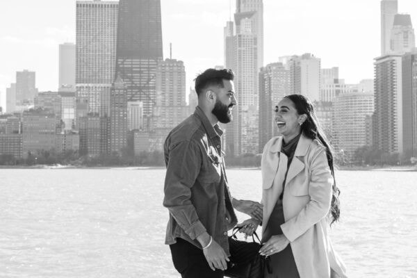 couple celebrates getting engaged in front of the chicago skyline