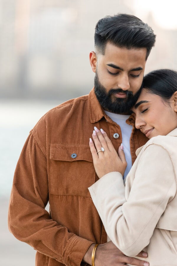 engaged couple poses for a photo in front of the chicago skyline