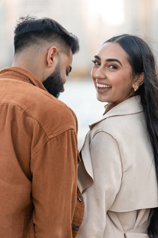 engaged couple poses for a photo in front of the chicago skyline