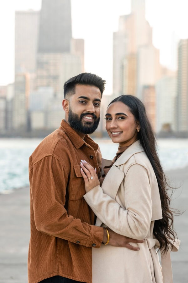 engaged couple poses for a photo in front of the chicago skyline